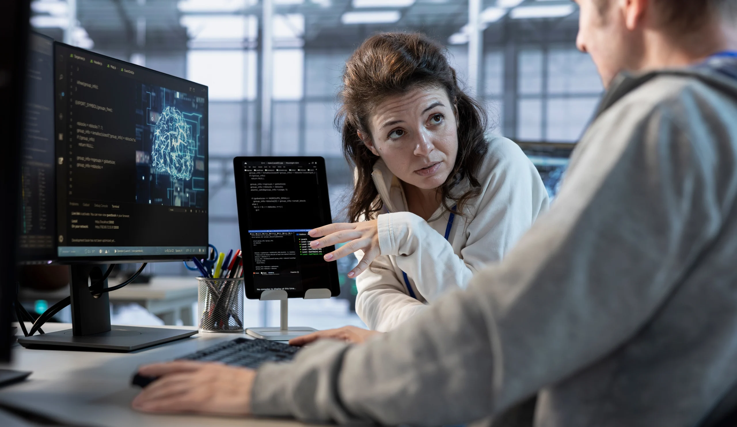A man and woman observe a computer screen, sharing insights and ideas during their interaction.